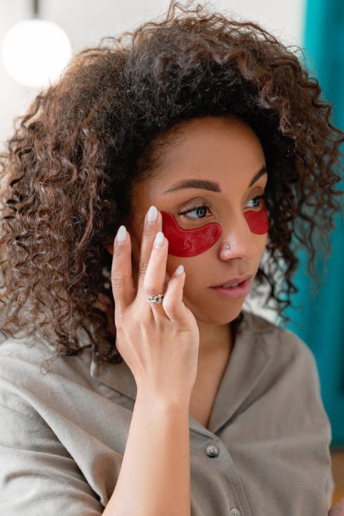 Woman in Brown Shirt With Red Under Eye Patches
