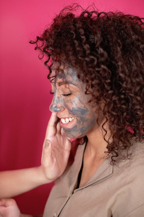Hand on Face of Woman With Black Face Mask 