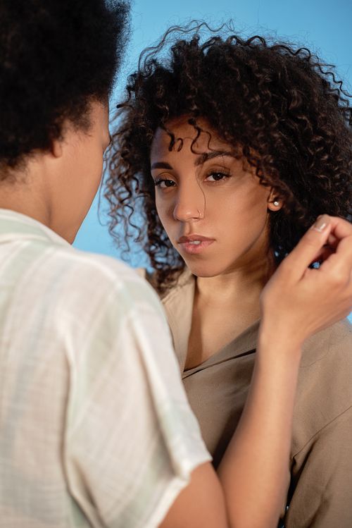 Free Tender moment between a diverse lesbian couple with curly hair, vibrant connection. Stock Photo