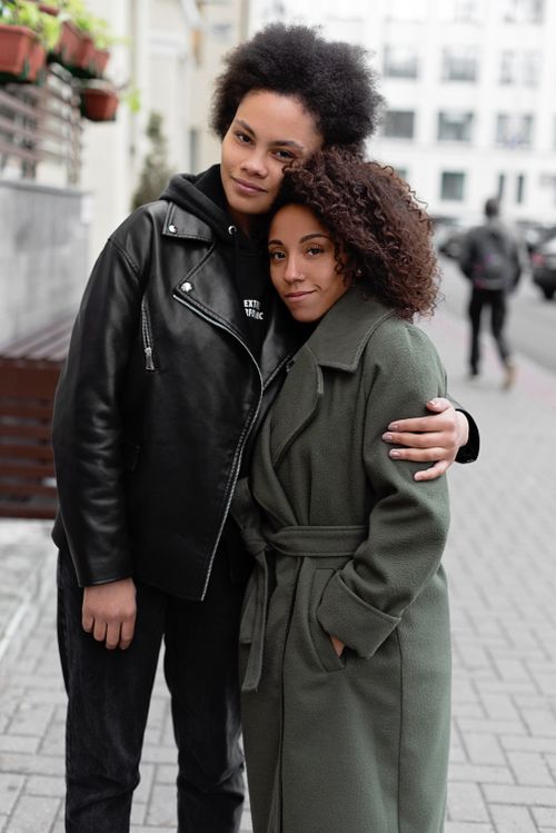 Free A loving couple stands outdoors, embracing in stylish jackets, exuding warmth and affection. Stock Photo