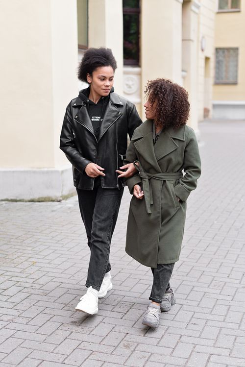 Free A loving lesbian couple strolls arm in arm down a city street, showcasing modern style and casual affection. Stock Photo