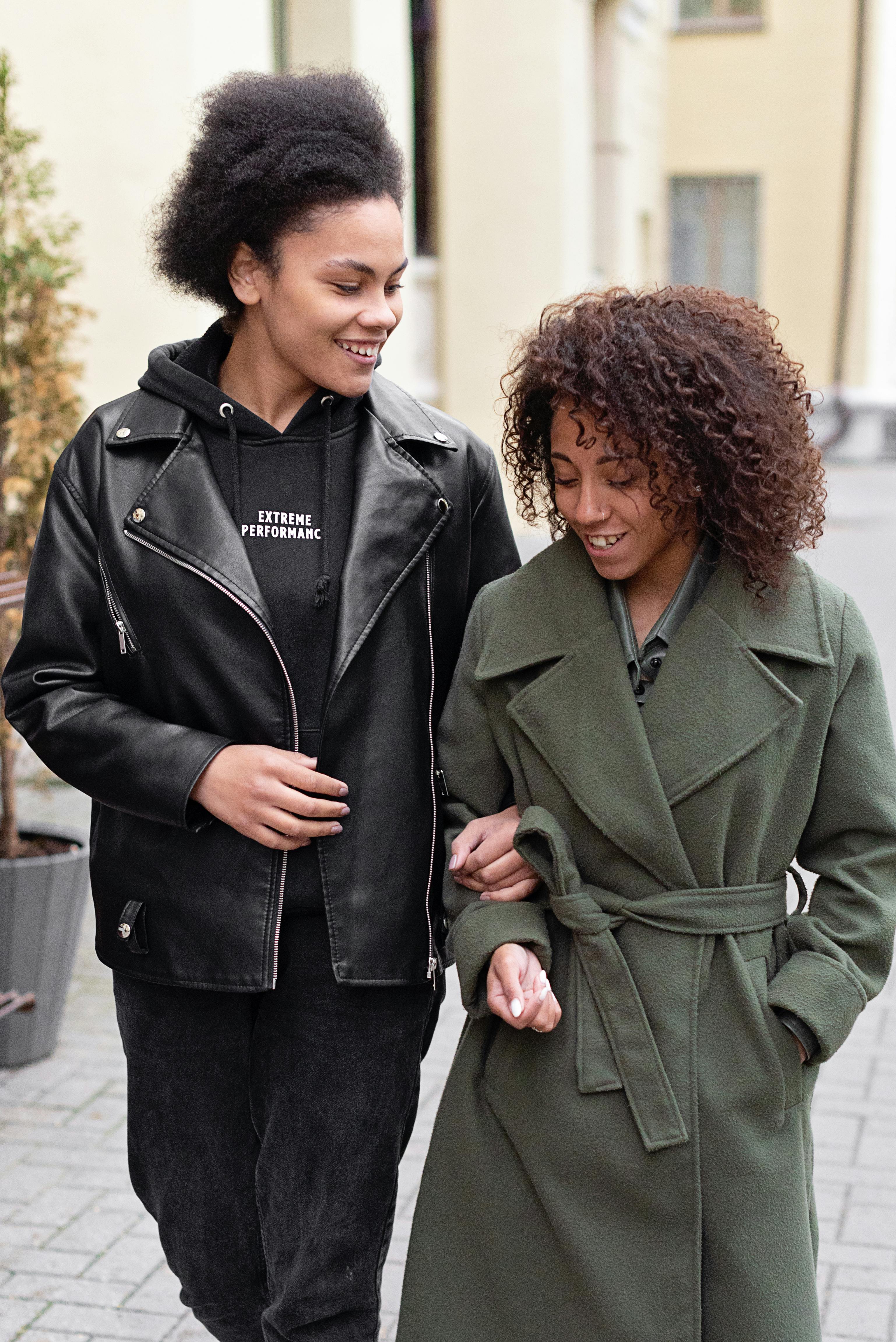 two women walking on street smiling