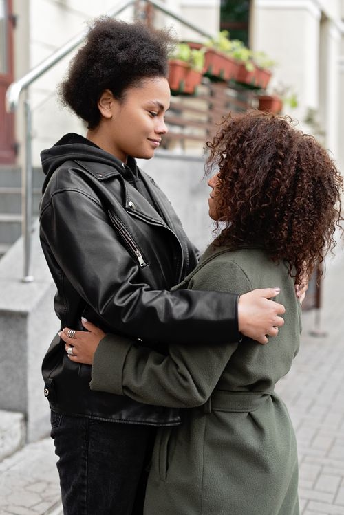 Free Two women sharing a tender moment outdoors, symbolizing love and companionship in an urban setting. Stock Photo
