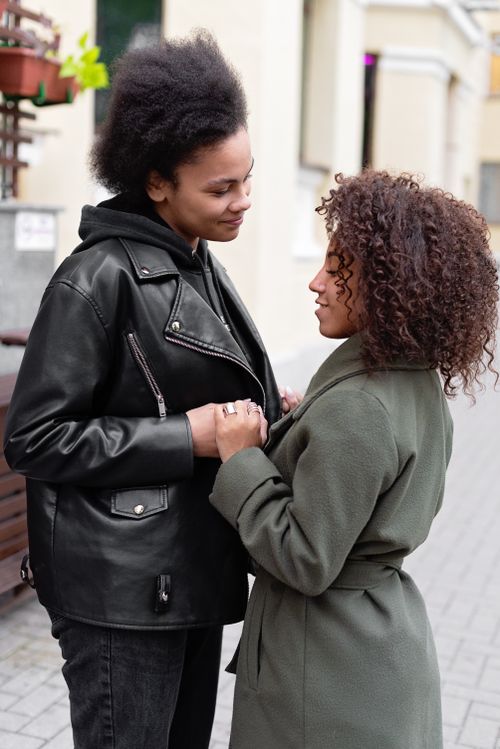 Free A loving couple embraces on a city sidewalk, conveying warmth and connection. Stock Photo