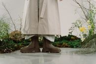 Woman in White Dress Wearing Brown Leather Boots Standing on Gray Concrete Floor