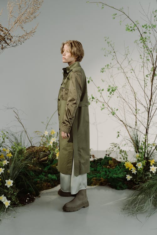  Woman in Brown Trench Coat Standing near the Plants