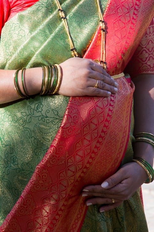 A Pregnant Woman in Traditional Clothes Touching Her Belly