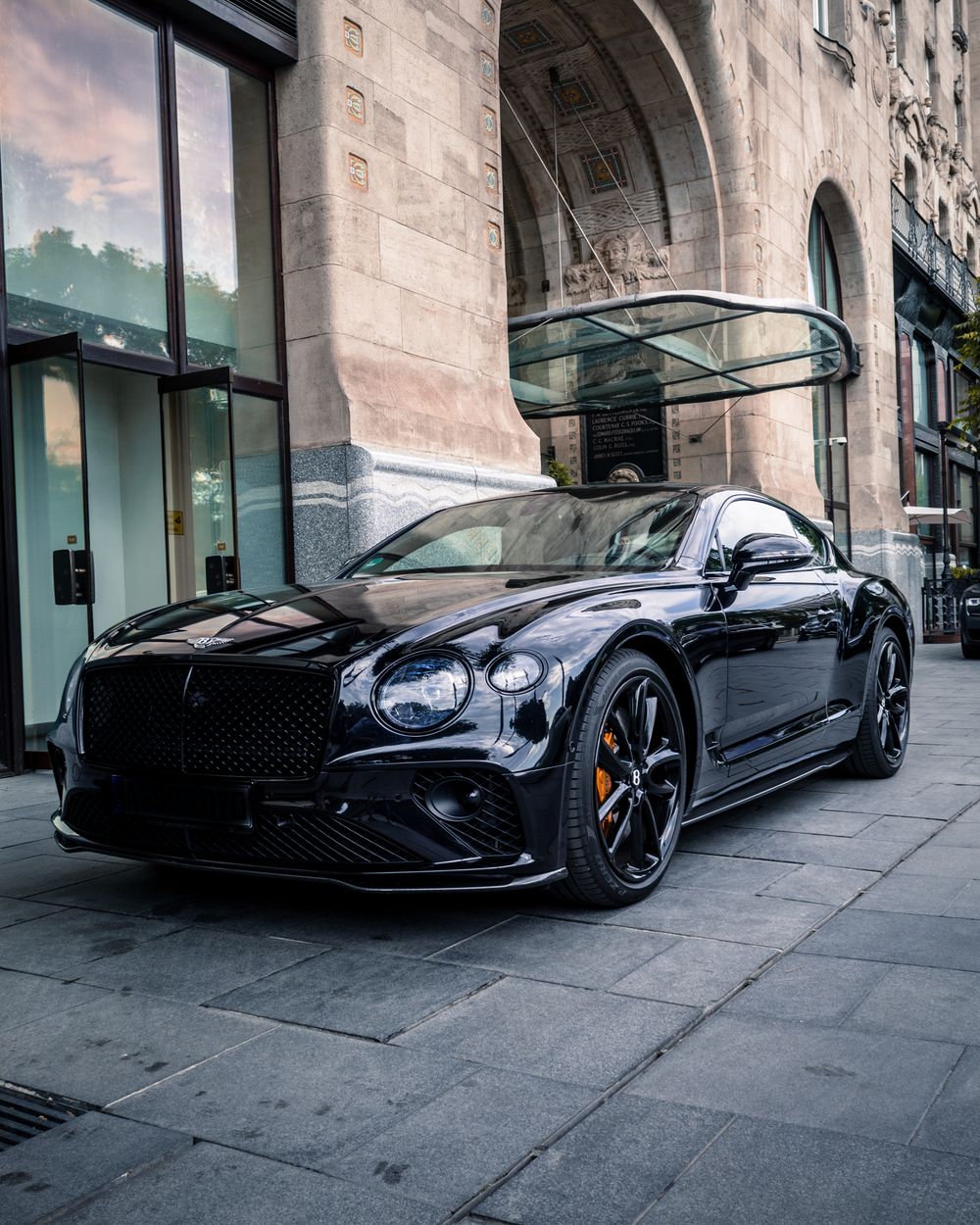 Dunkles Gran-Turismo-Coupé an einer städtischen Straße