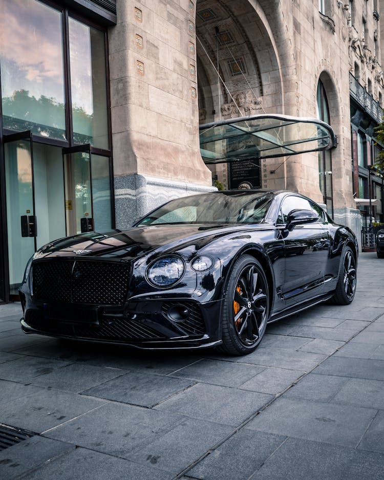 A Black Bentley Luxury Car Parked In Front Of A Building