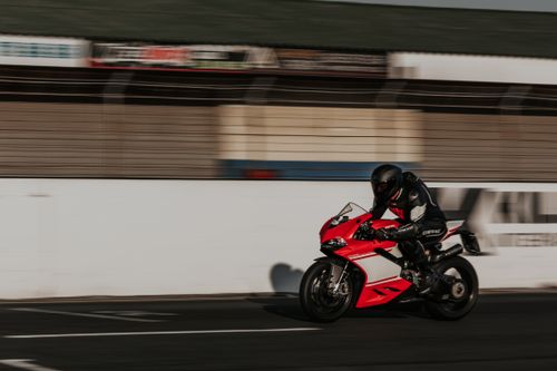 Free Dynamic shot of a motorbike racer speeding on the track, showcasing fast-paced motorsport action. Stock Photo