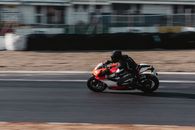 Man in Orange and Black Sports Bike on Road