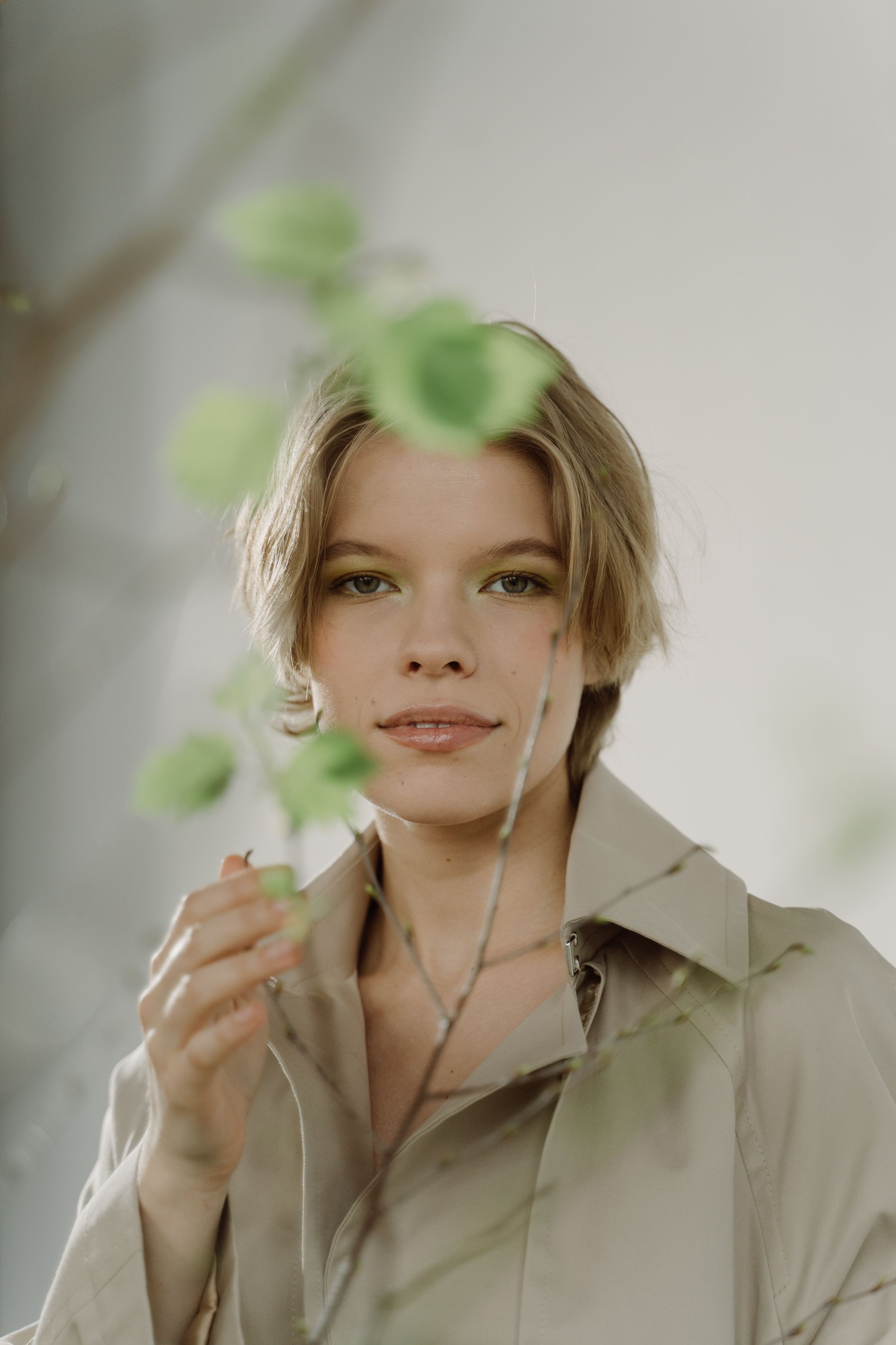 Woman in Brown Coat Holding Green Leaves · Free Stock Photo