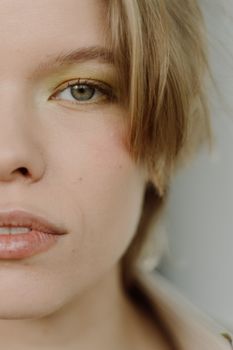 Close-up of a young woman with soft makeup and blonde hair, showcasing a serene expression.