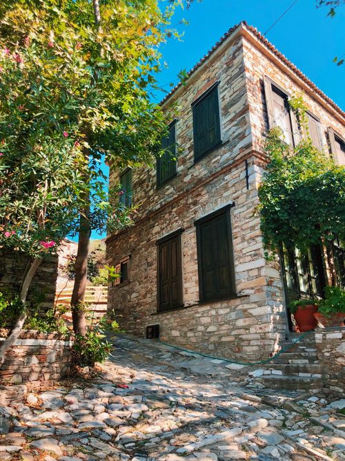 Free Explore a quaint old stone house with cobblestone path in Söke, Aydın, Turkey, surrounded by lush greenery. Stock Photo