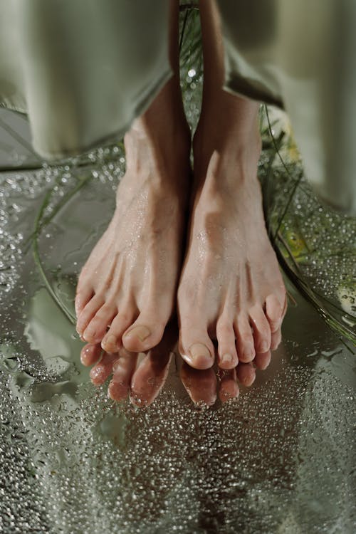 Free Persons Feet on Gray Wet Floor Stock Photo