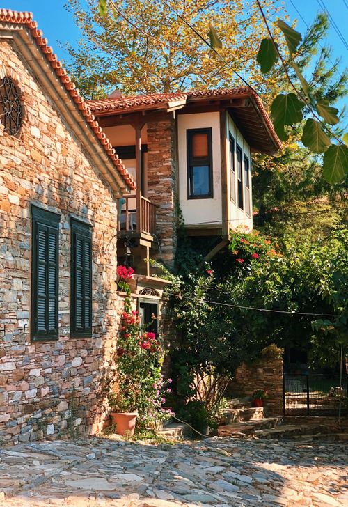 Free Rustic stone house facade with lush garden in Söke, Turkey. Stock Photo