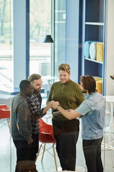 A diverse group of four adult men engaged in a friendly discussion in a modern office setting.