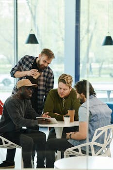 A multicultural group of young professionals collaborating over coffee in a modern setting.