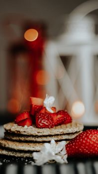 Close-up of waffles topped with fresh strawberries and powdered sugar, creating a delectable dessert scene.
