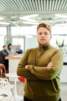 A confident man standing in a modern coffee shop workspace, exemplifying leadership.