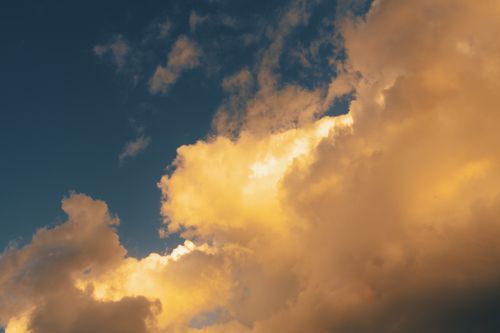Free Beautiful golden clouds illuminated during twilight, creating a serene and atmospheric sky. Stock Photo
