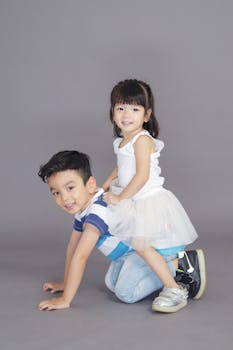 两个快乐的孩子在工作室里嬉戏地摆着姿势，散发着欢乐与团结