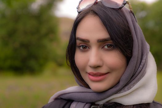 Smiling woman with headscarf outdoors in Iran, vibrant and natural look.