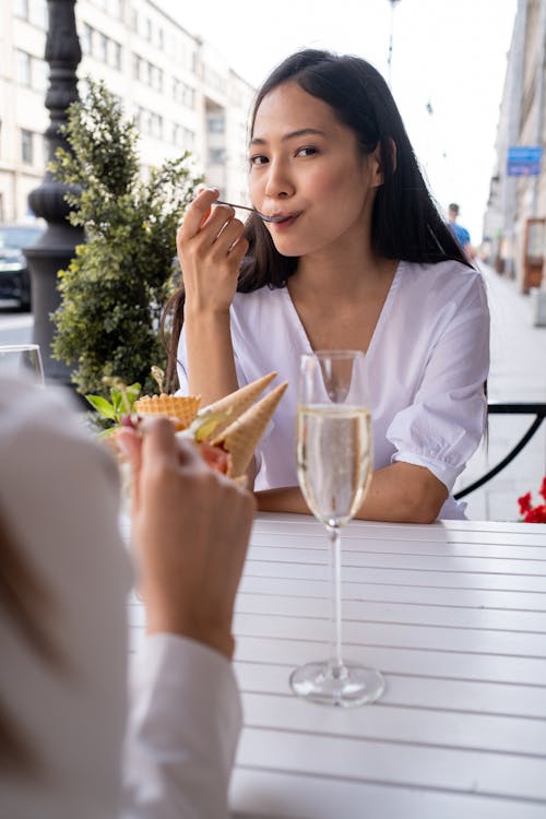 Безкоштовне стокове фото на тему «азіатська жінка, білий топ, їжа»
