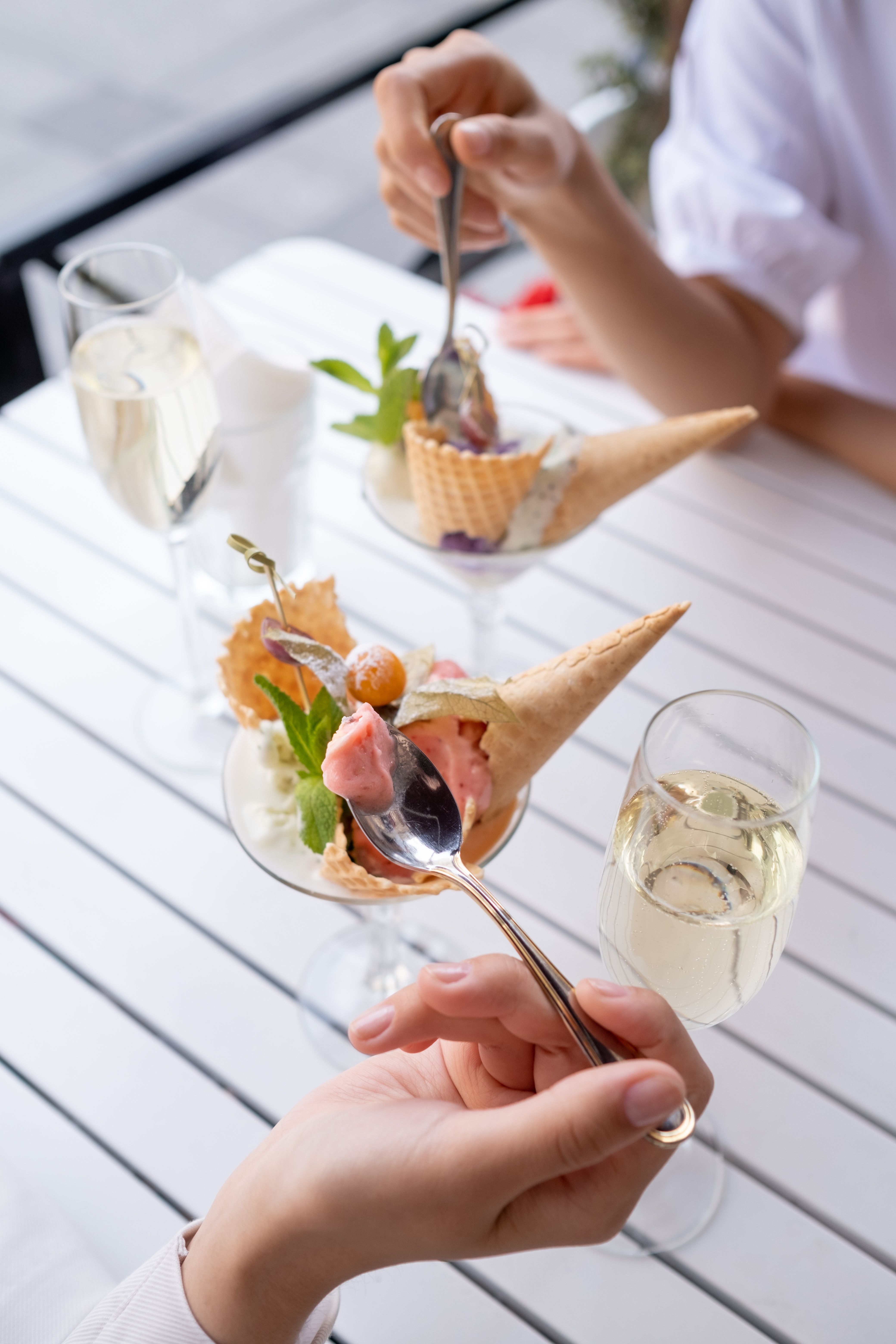 Capture an elegant moment with ice cream and champagne on a sunny patio. Perfect for lifestyle themes.