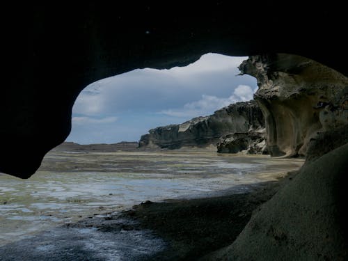 Free View of Low Tide on Beach Cove from a Cave Stock Photo