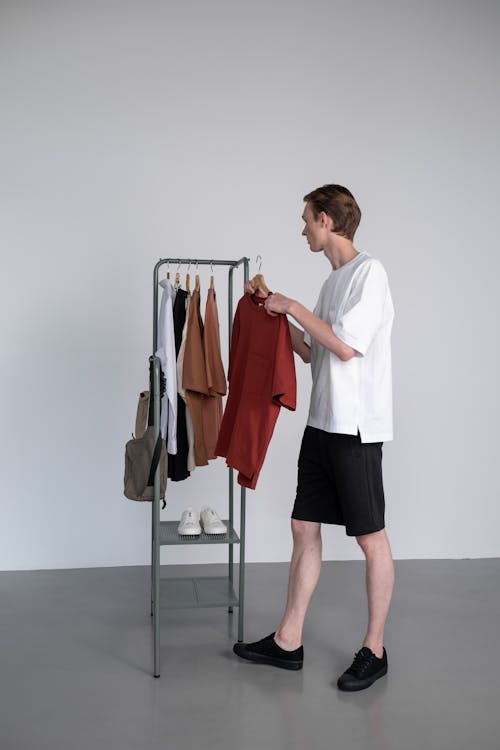 Man in White Shirt Holding a Red Shirt