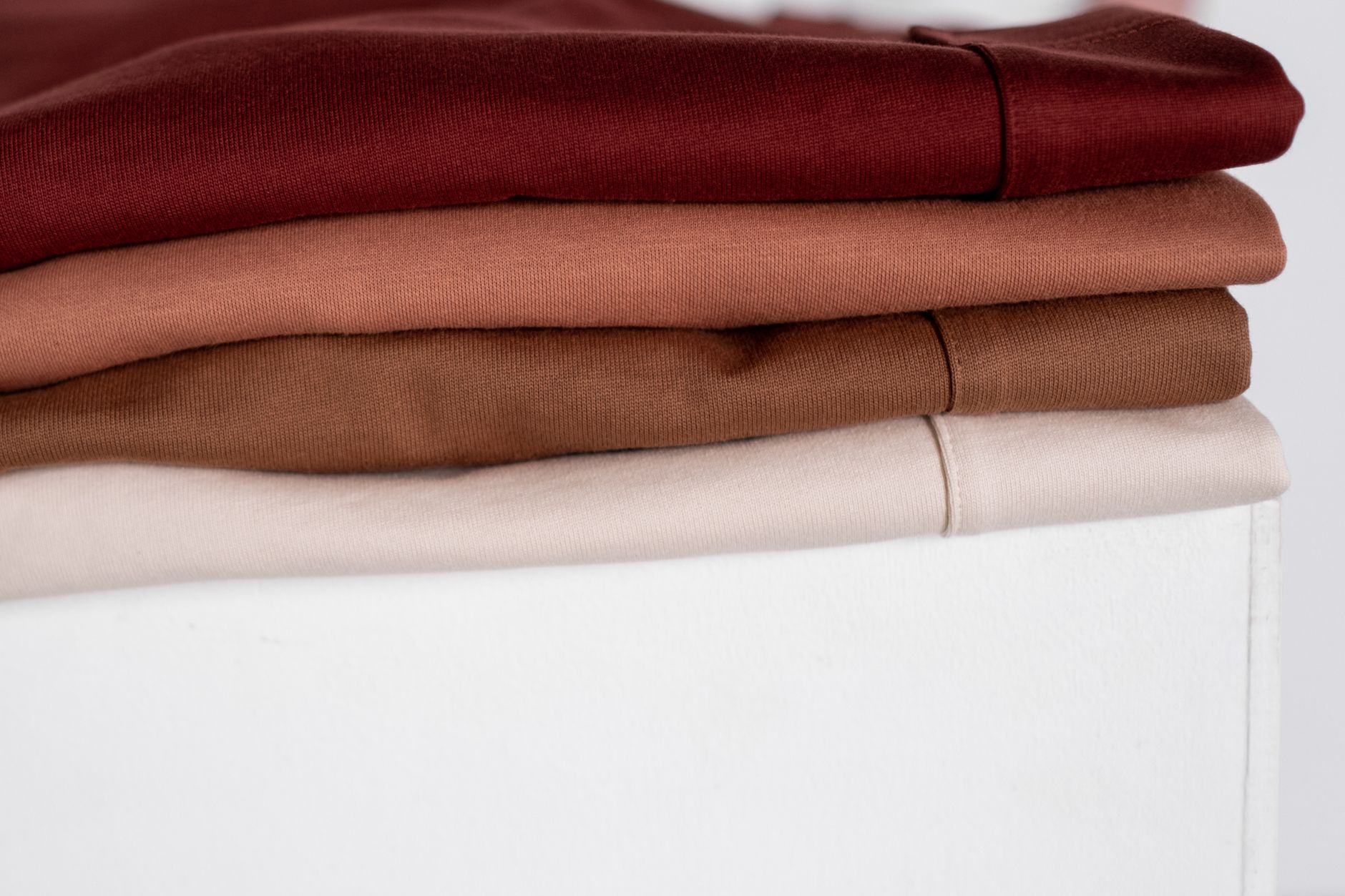 きれいに重ねられた、中間色の服のたたみ方