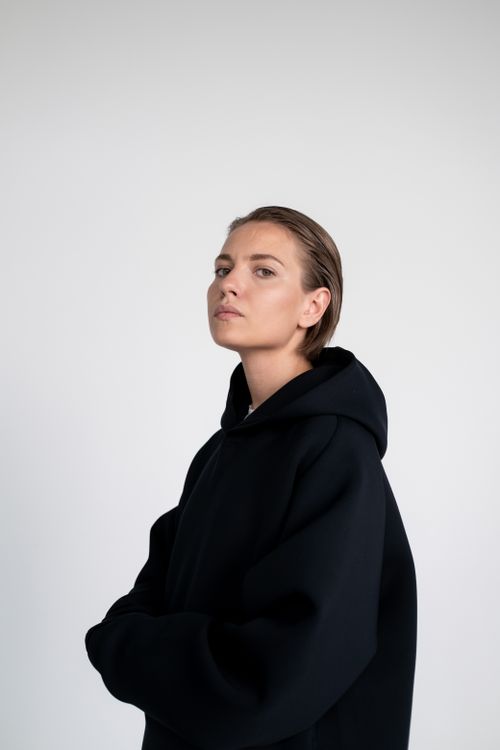 Free Stylish portrait of a woman wearing a black hoodie against a white background. Stock Photo