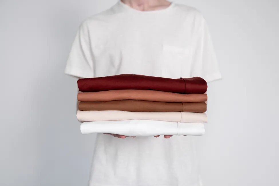Pile de t-shirts vierges de plusieurs couleurs tenue à bras, le poste à financer avant toute impression