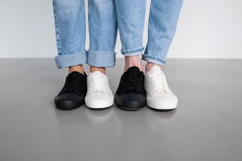 People in Blue Denim Jeans and Black and White Sneakers