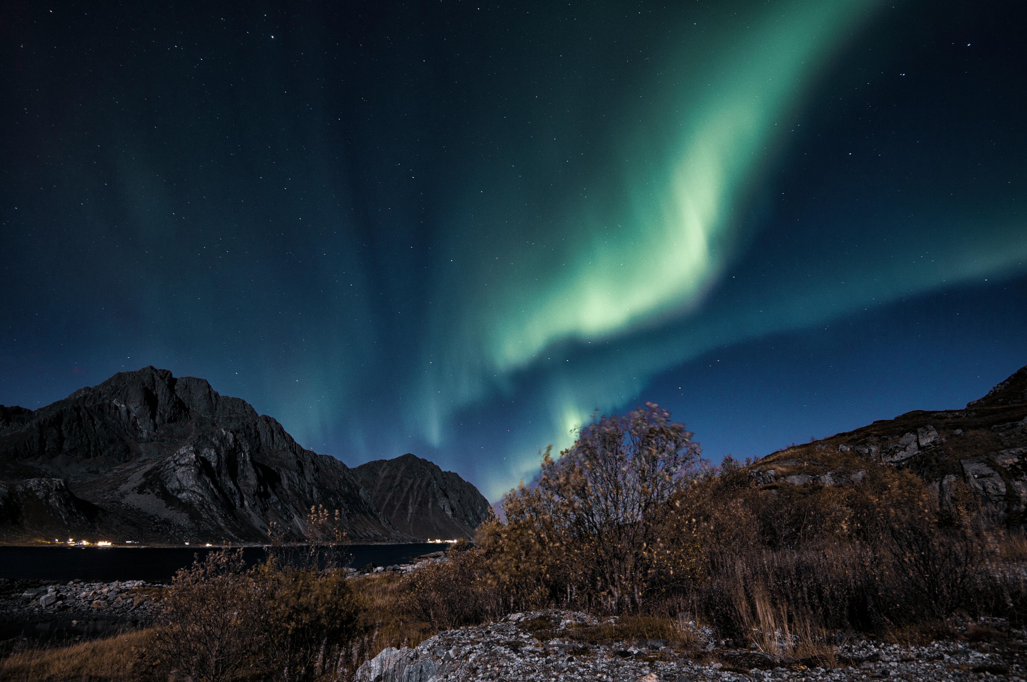 Stunning aurora borealis over rugged mountains in Nordland, capturing nature's vibrant night display.
