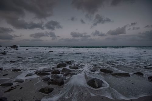 Free A scenic view of a rocky Nordland beach during twilight, with dark clouds and a mesmerizing sea. Stock Photo