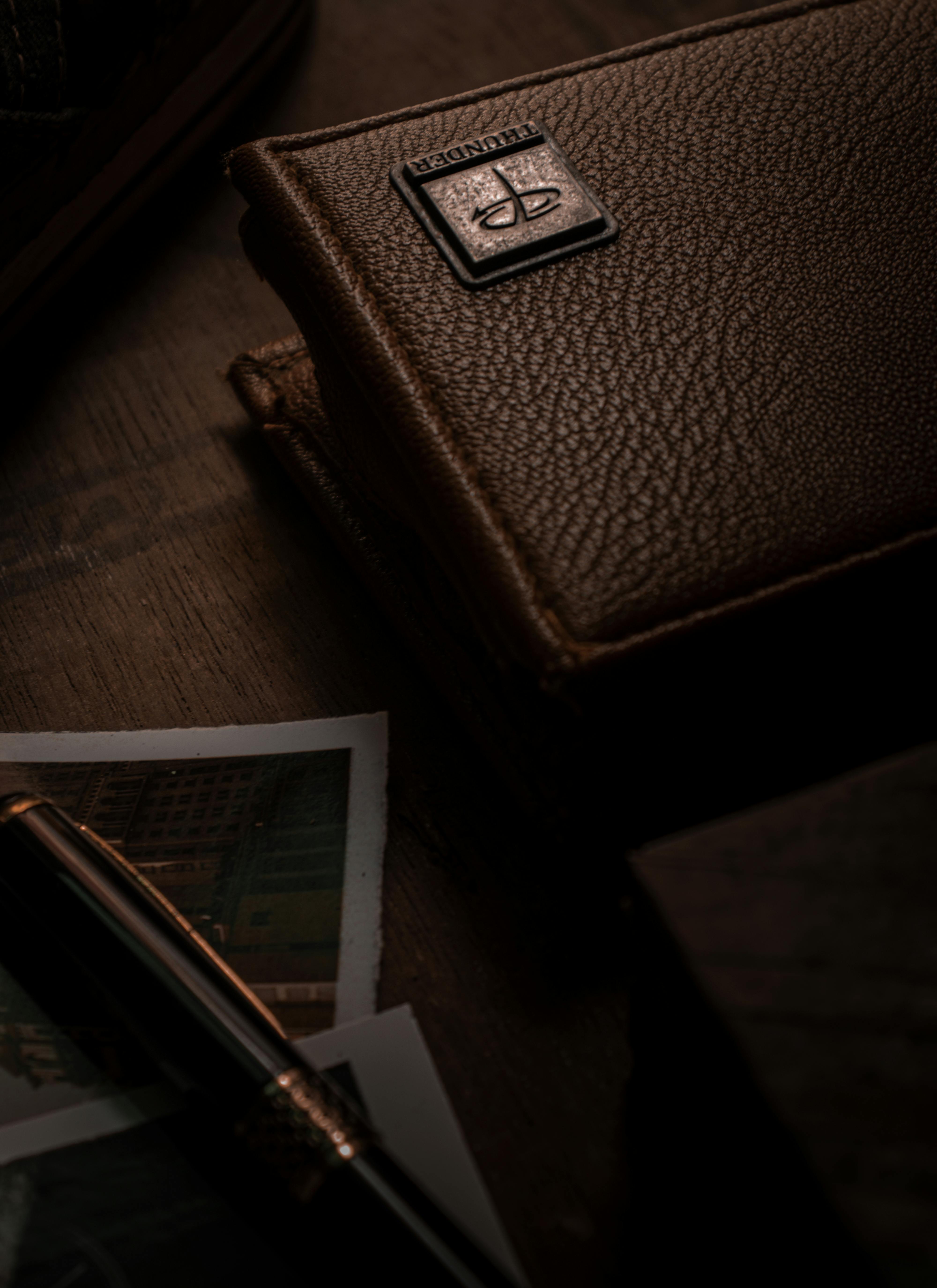 Stylish brown leather wallet with embossed texture and metallic emblem.