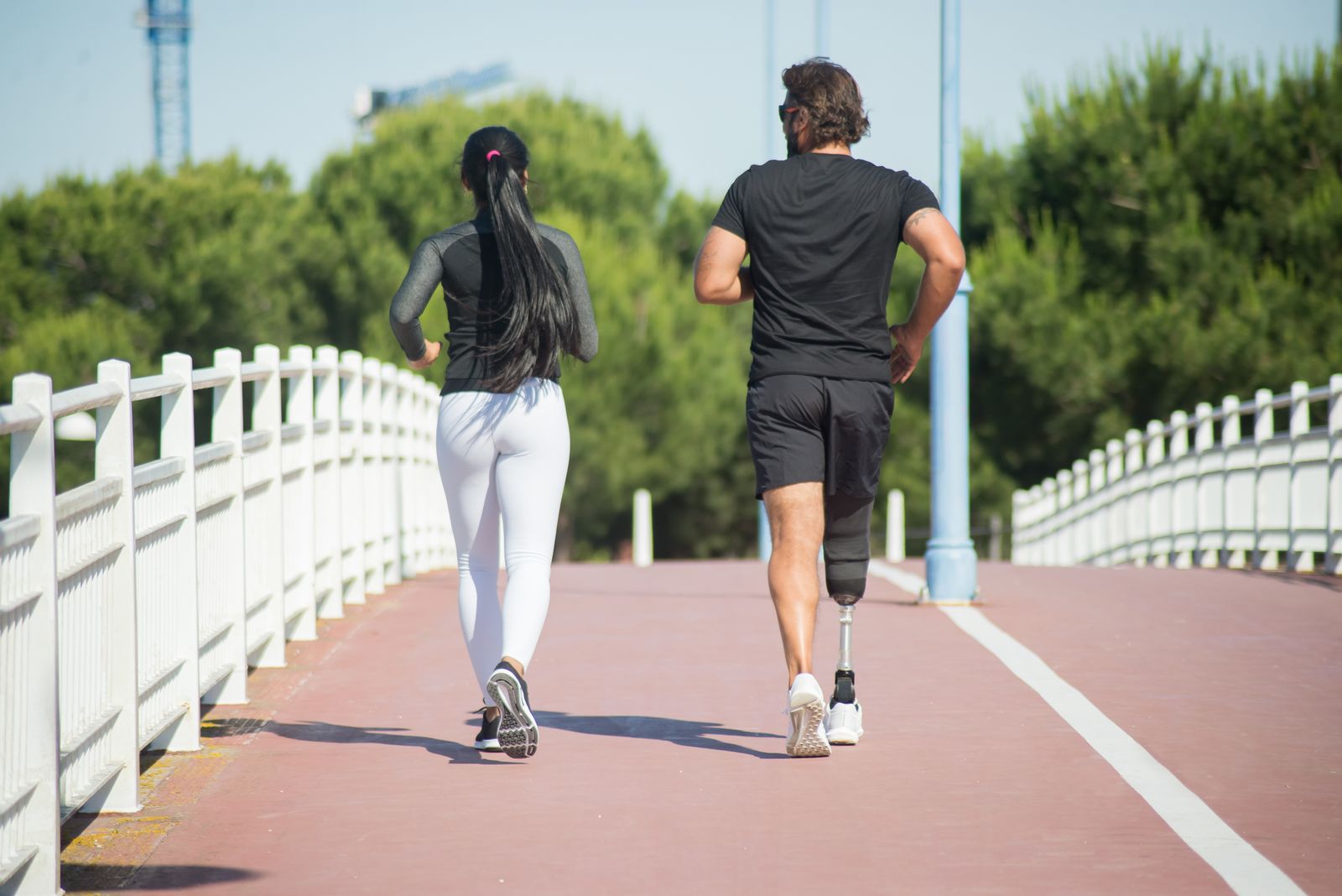 Runner stretching lower legs outdoors before training in bright daylight