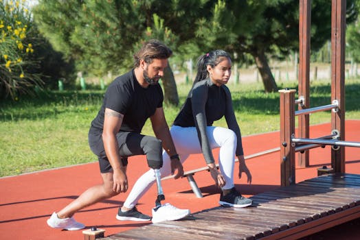 Prosthetic athlete and trainer stretching in outdoor park setting.