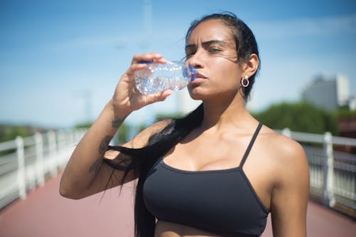 Woman in Black Sports Bra drinking Water