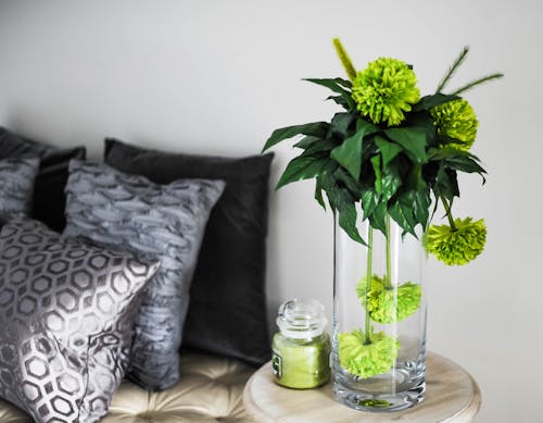 무료 갈색 나무 작은 테이블에 녹색 꽃과 투명 유리 꽃병 스톡 사진