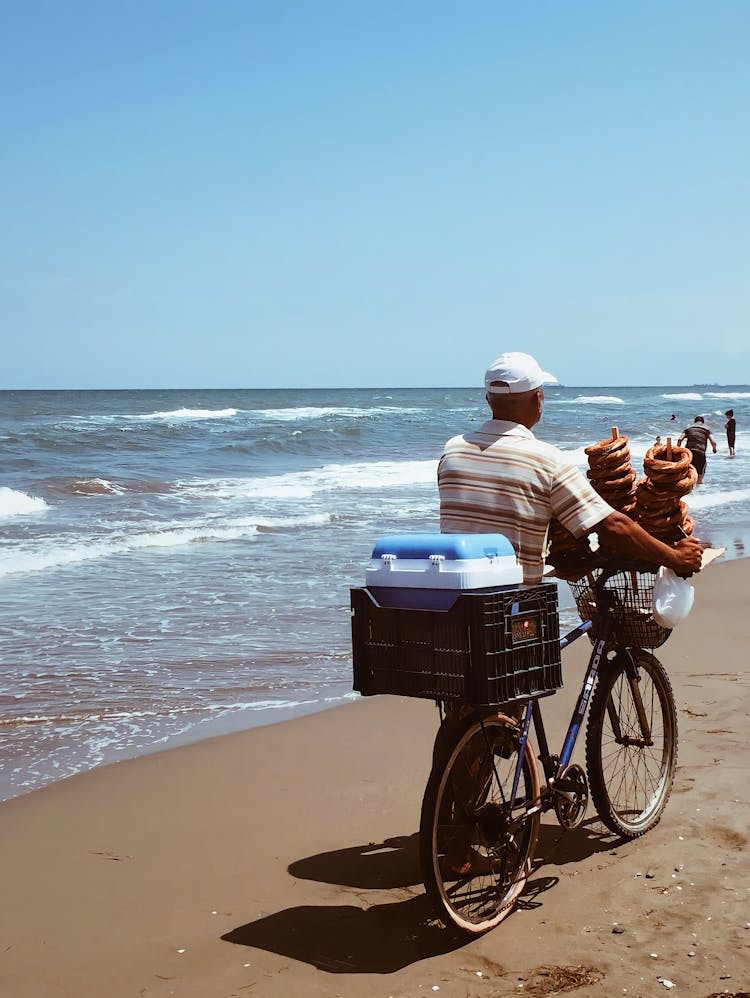 Man Pushing Bike At The Beach