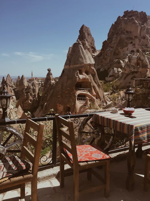 Cappadocian Rock-Cut Dwellings With Chairs in the Foreground