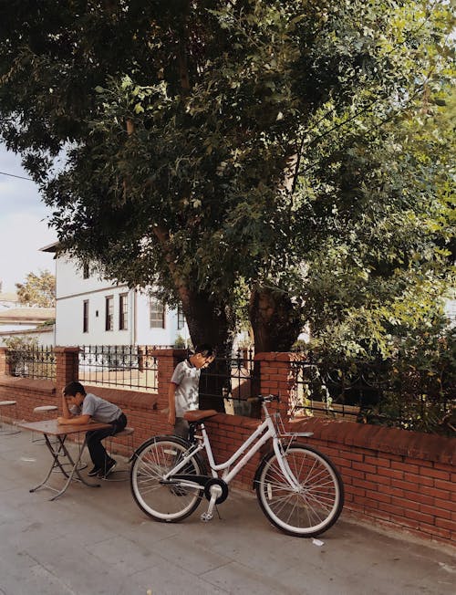 Бесплатное стоковое фото с бетонный забор, велосипедист, вертикальный выстрел
