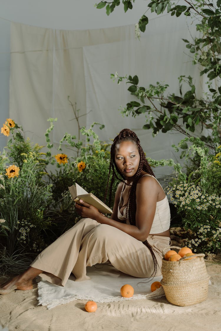 Woman Holding Book While Looking Over Shoulder