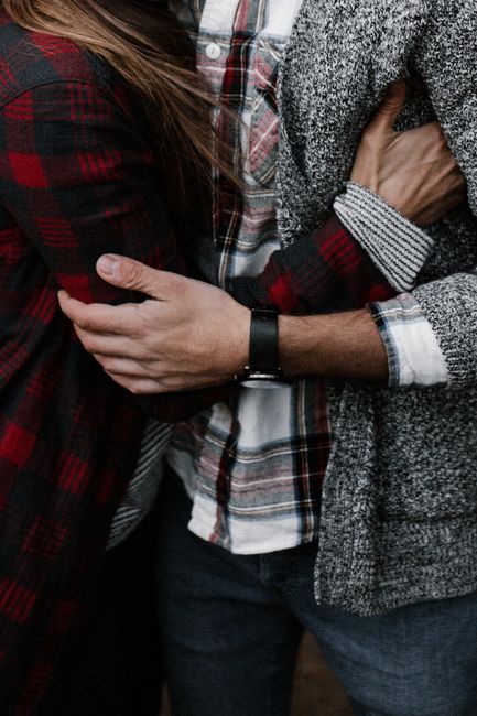 Close-up of a couple embracing in plaid flannel and sweater, showcasing warmth and intimacy.