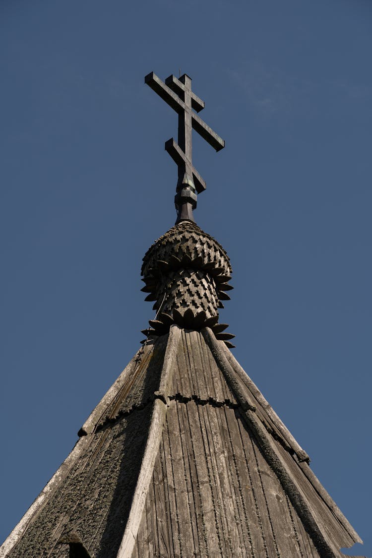 Low Angle Shot Of A Cross Under The Blue Sky