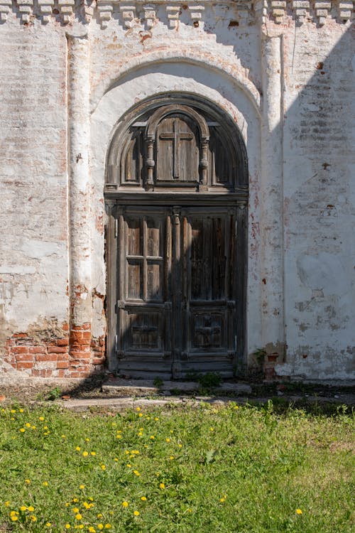 Brown Wooden Arched Door on Concrete Building