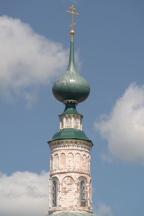 Free Close-up of an Orthodox church tower featuring a green dome and golden cross against a blue sky. Stock Photo